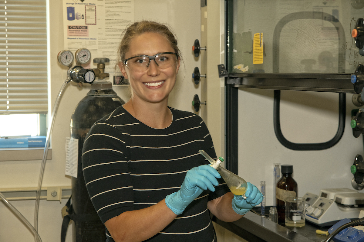 Professor Jenkins in her lab holding a beaker.