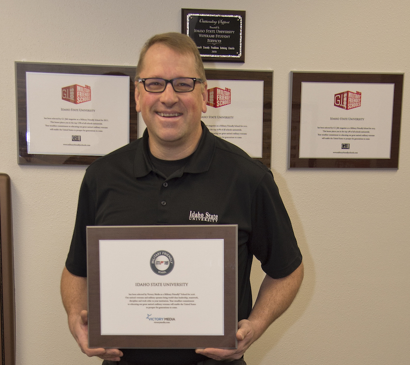 Veteran Student Services Center's Todd Johnson, displaying awards the center has received for 2018.