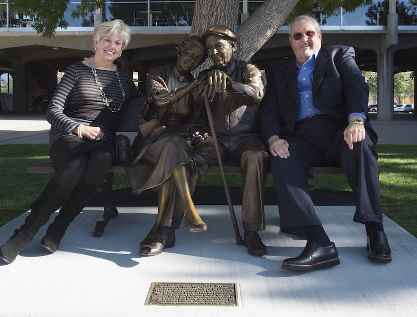 Photo of Marilyn and Bill Byrne sitting on Valentine sculpture