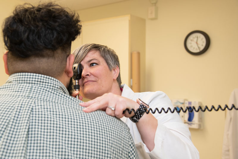 Nursing student checks a patients eyes