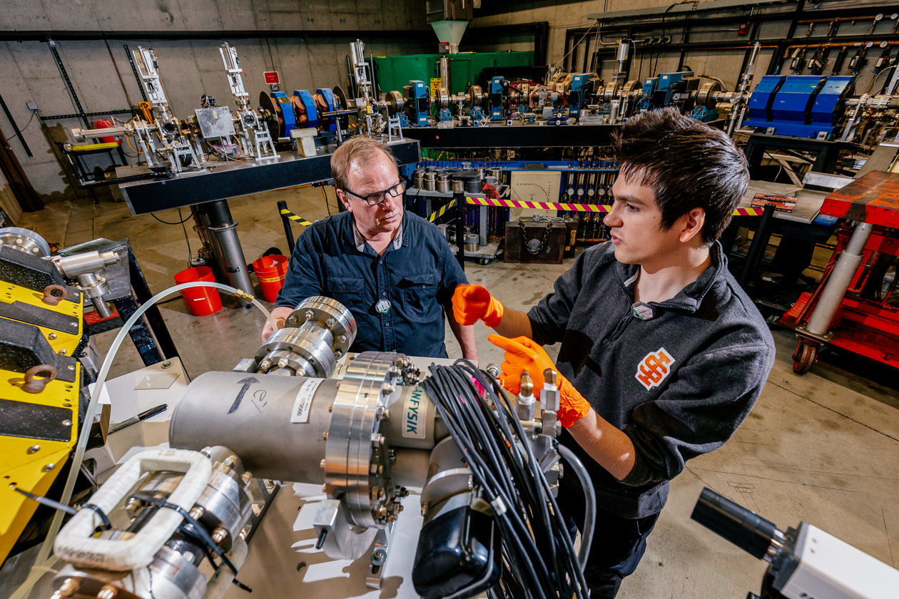 Daniel Dale and Kean Martinic (student) discuss the isotope project inside the Idaho Accelerator Center on Idaho State University’s Pocatello Campus.