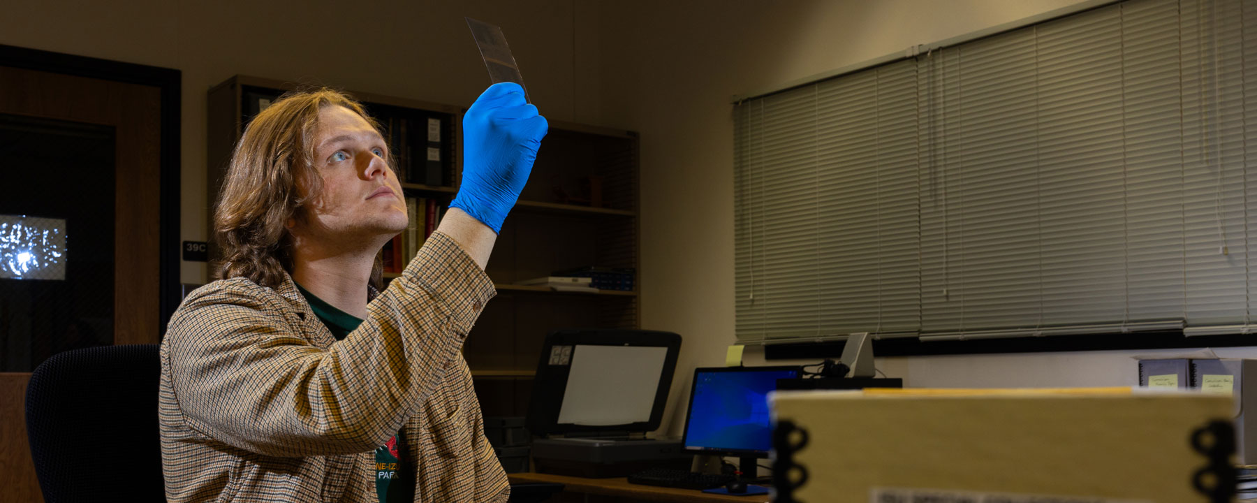 Brady Cooke, student and Career Path Intern for Idaho State University, views a negative from the Lloyd S. Furniss collection used as part of a Ken Burns’ documentary “The American Buffalo.” The collection was donated by the family of Furniss to ISU’s Special Collections and Archives.