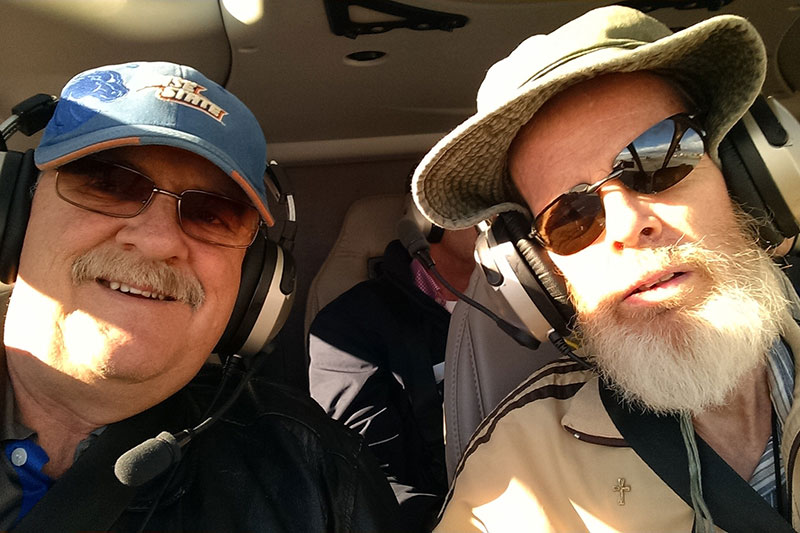 Steve and Bill Smylie in a helicopter cockpit on one of their adventures in recent years
