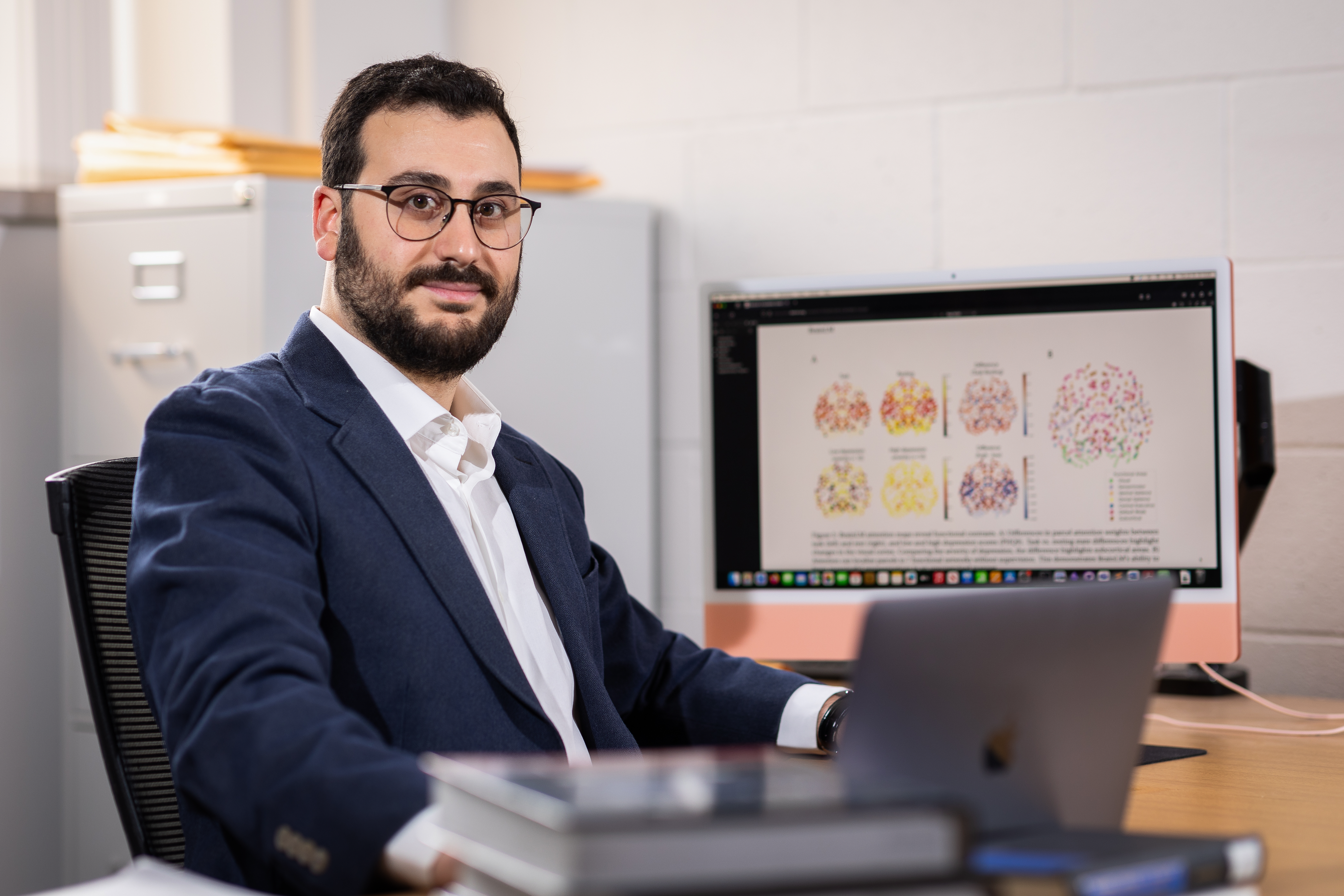 Emanuele Zappala sitting in front of a monitor showing brain scans