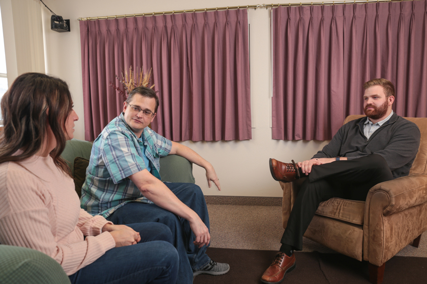 Three people sitting in a group and talking